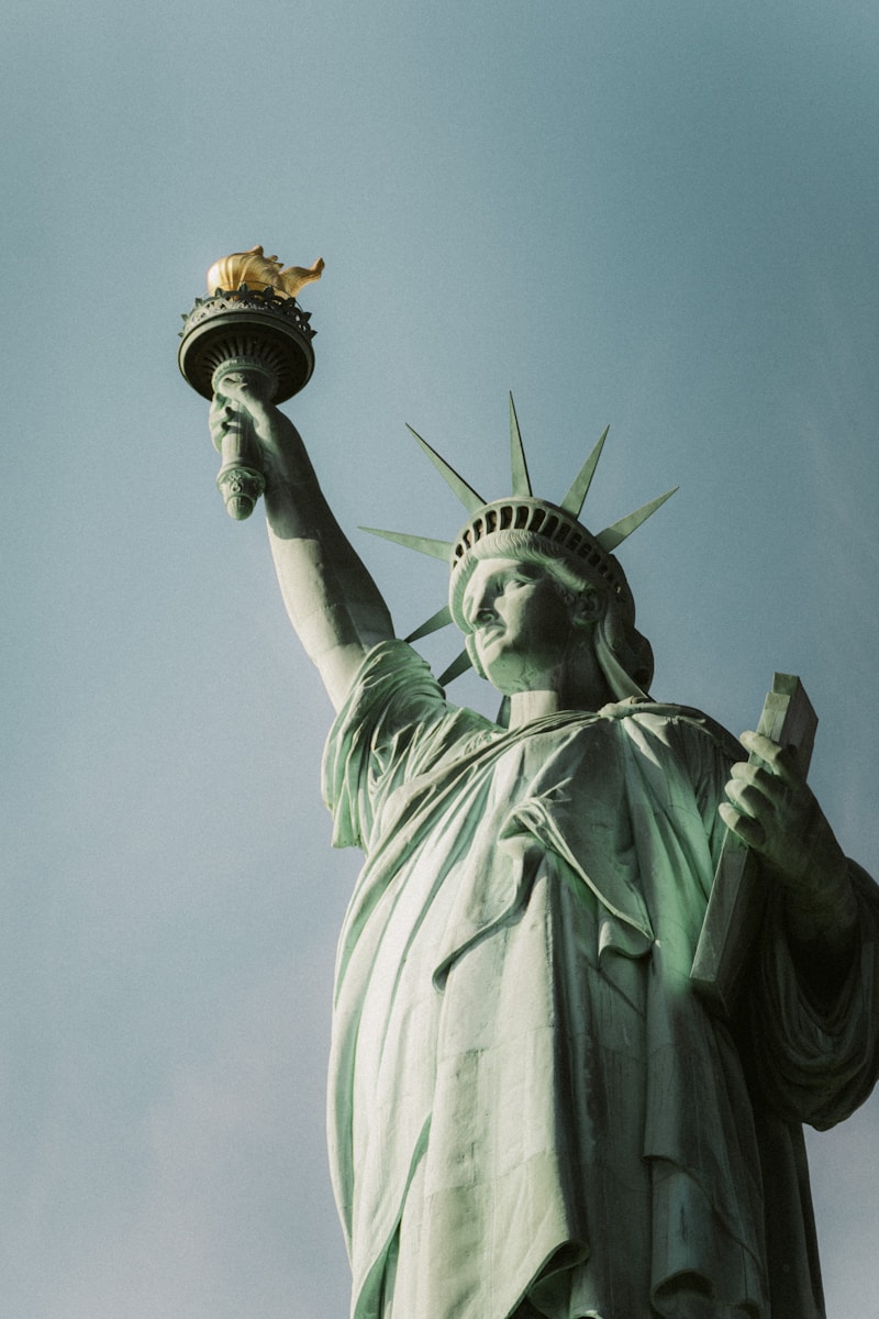 The statue of liberty is holding a bird in its hand